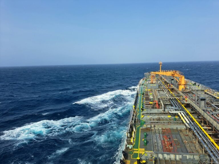 Cargo ship navigating through the ocean under clear skies, showcasing maritime transportation.
